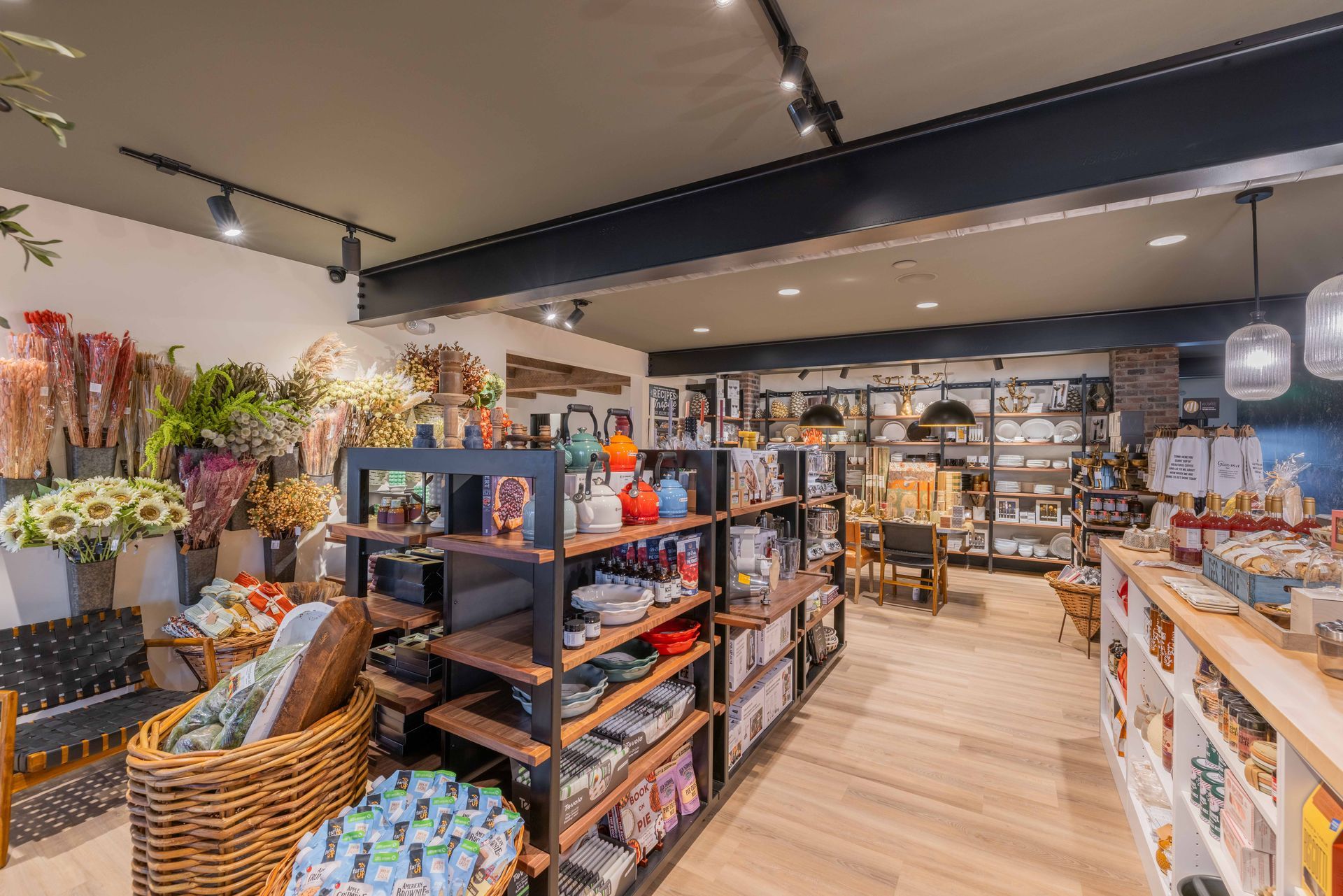 Bright retail shop interior with shelves of colorful products, baskets, and wooden flooring