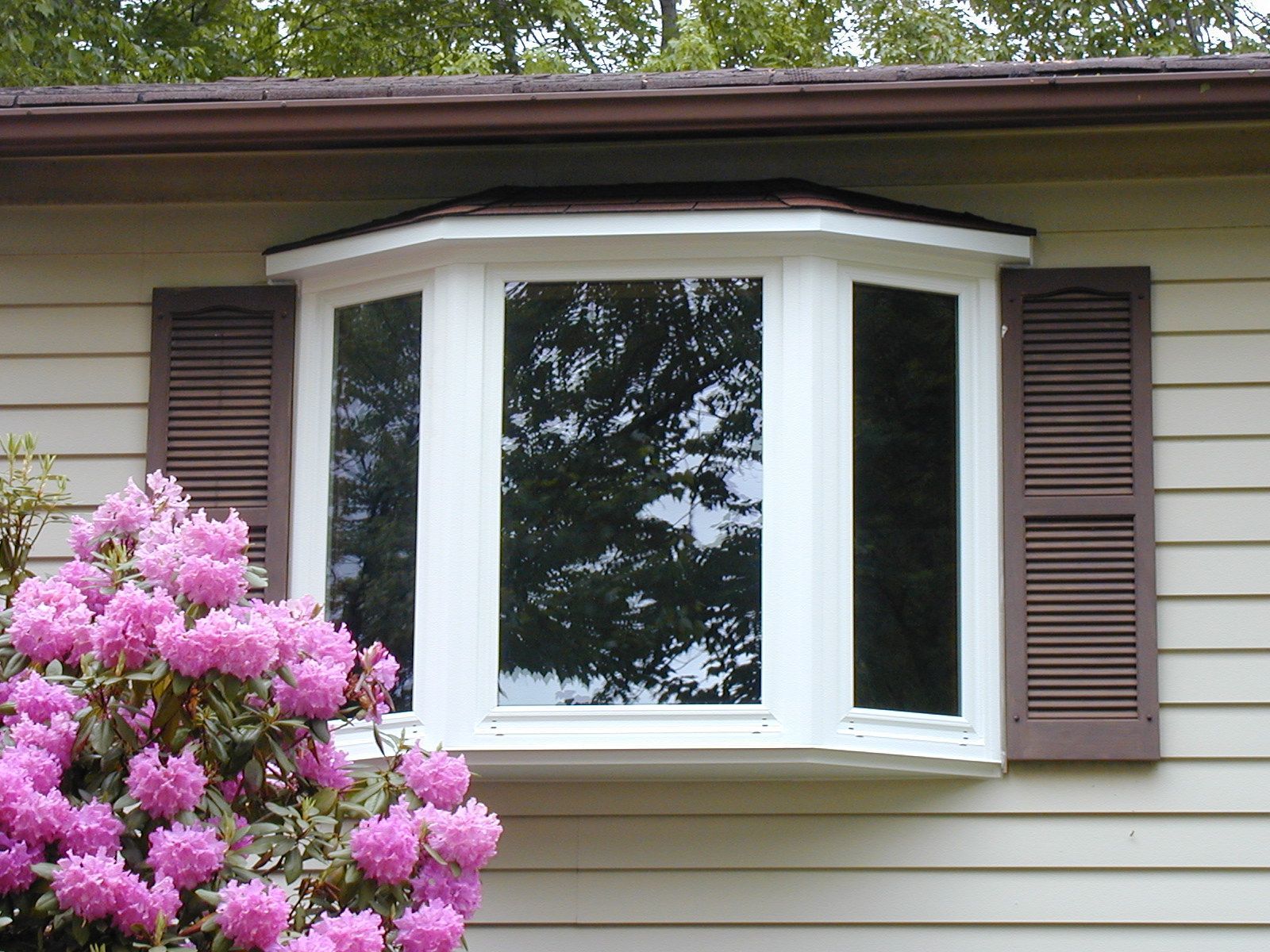 A house with a bay window and brown shutters