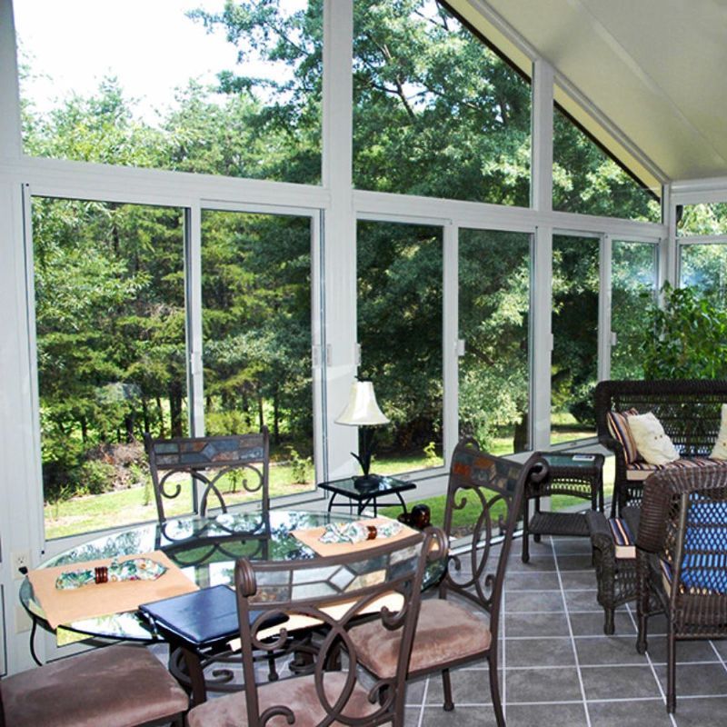 A sun room with a table and chairs and lots of windows