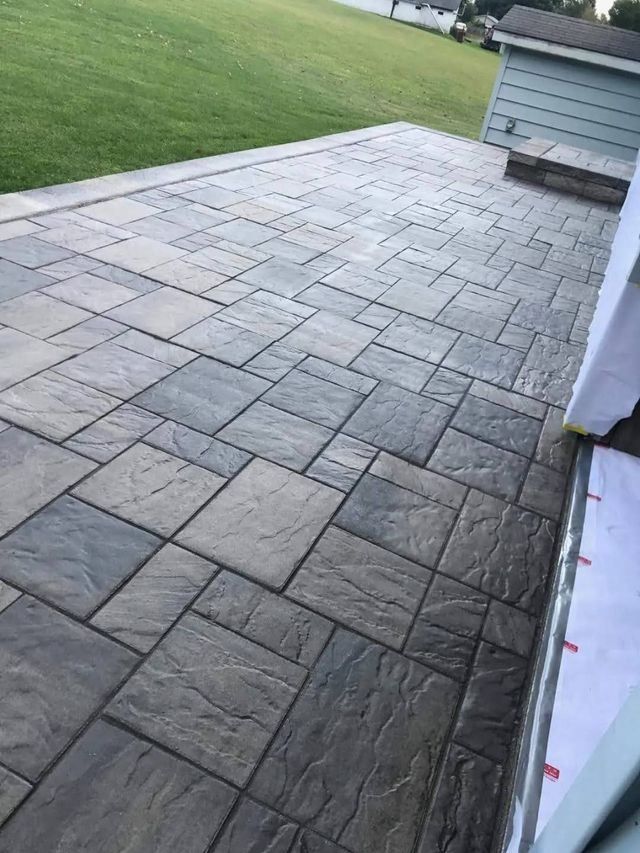 A patio with a lot of tiles and a house in the background