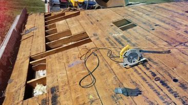 A circular saw is sitting on top of a wooden roof.