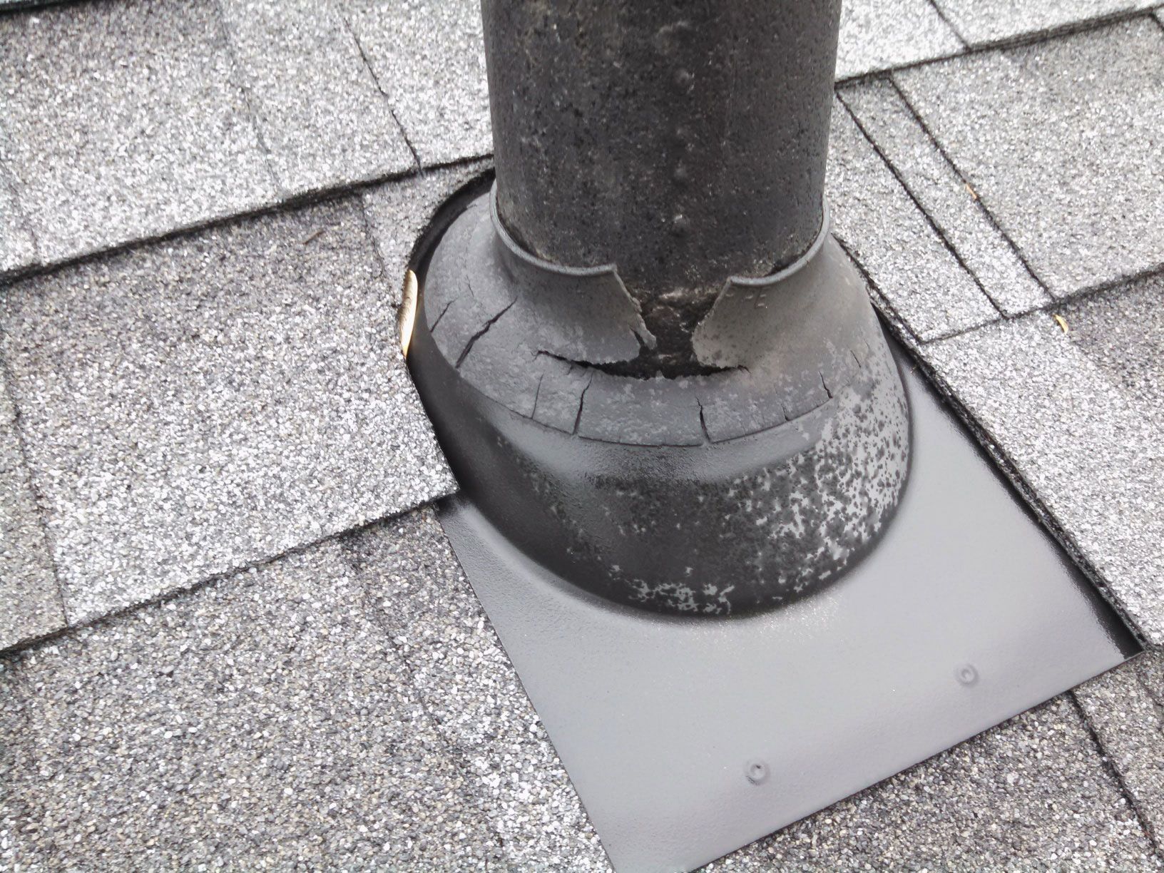 A chimney is sitting on top of a roof with shingles