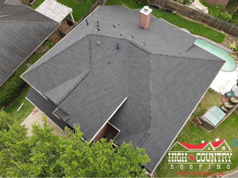 An aerial view of a house with a high country roofing logo