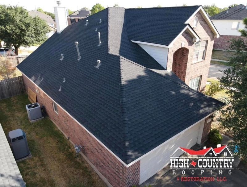 An aerial view of a house with a black roof from high country roofing