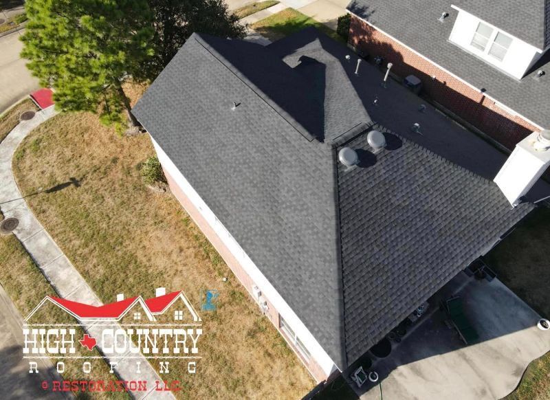 An aerial view of a house with a roof from high country roofing