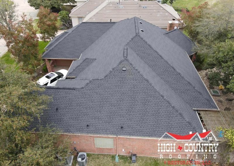An aerial view of a house with a black roof