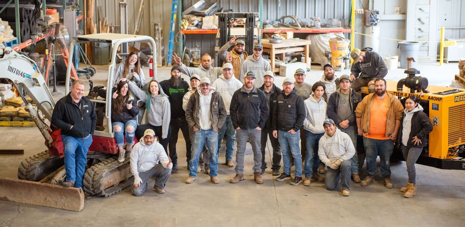A group of people are posing for a picture in a warehouse.