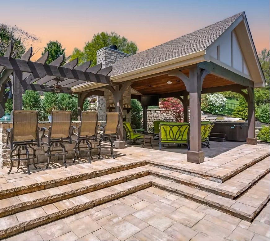 Outdoor patio with a pergola, bar seating, and a covered seating area.