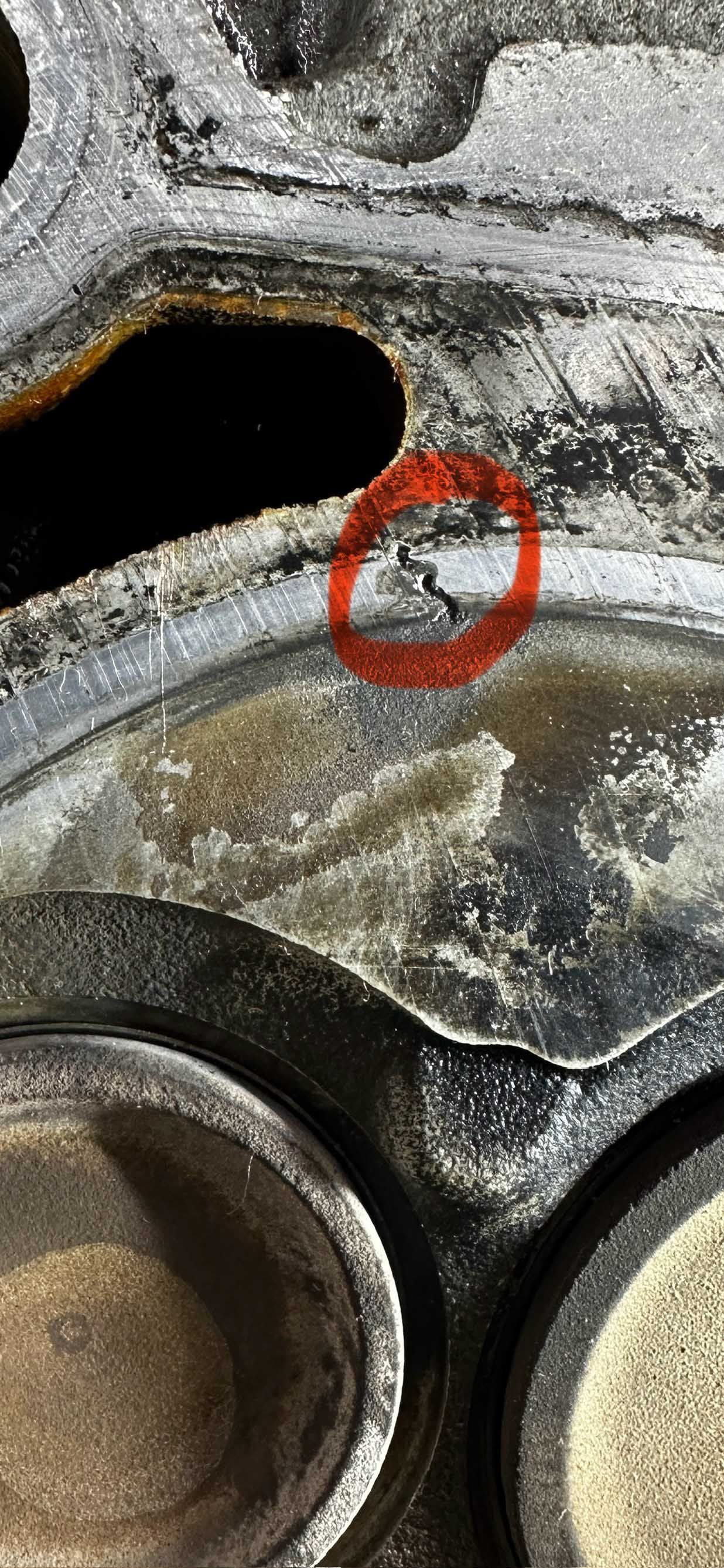 Engine cylinder head with a crack, circled in red.