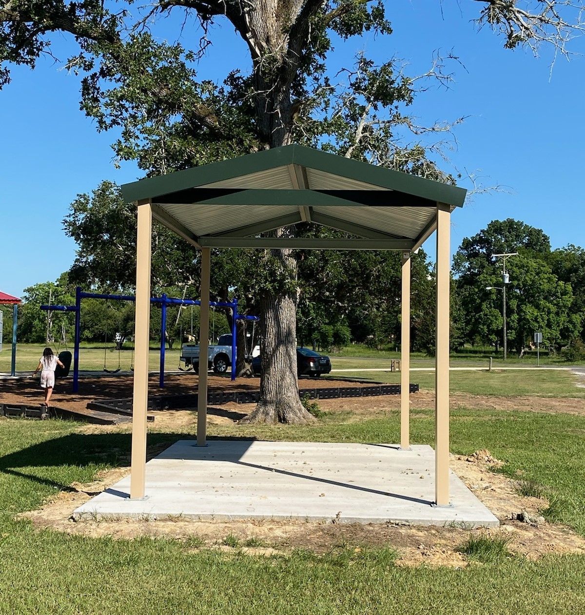 A gazebo in a park with a tree in the background