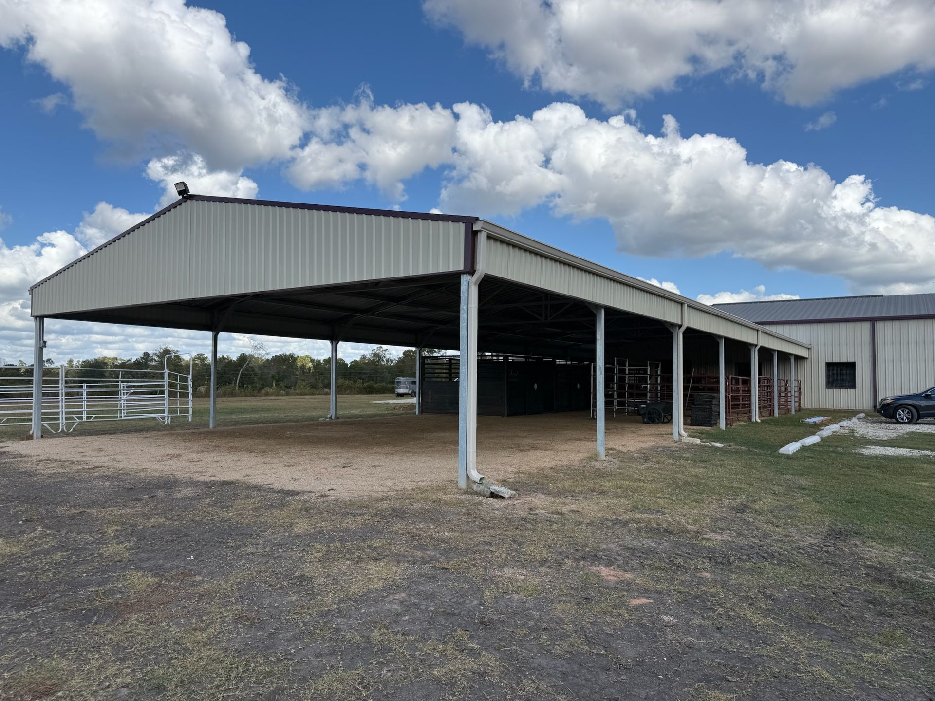 A large metal building with a car parked underneath it.