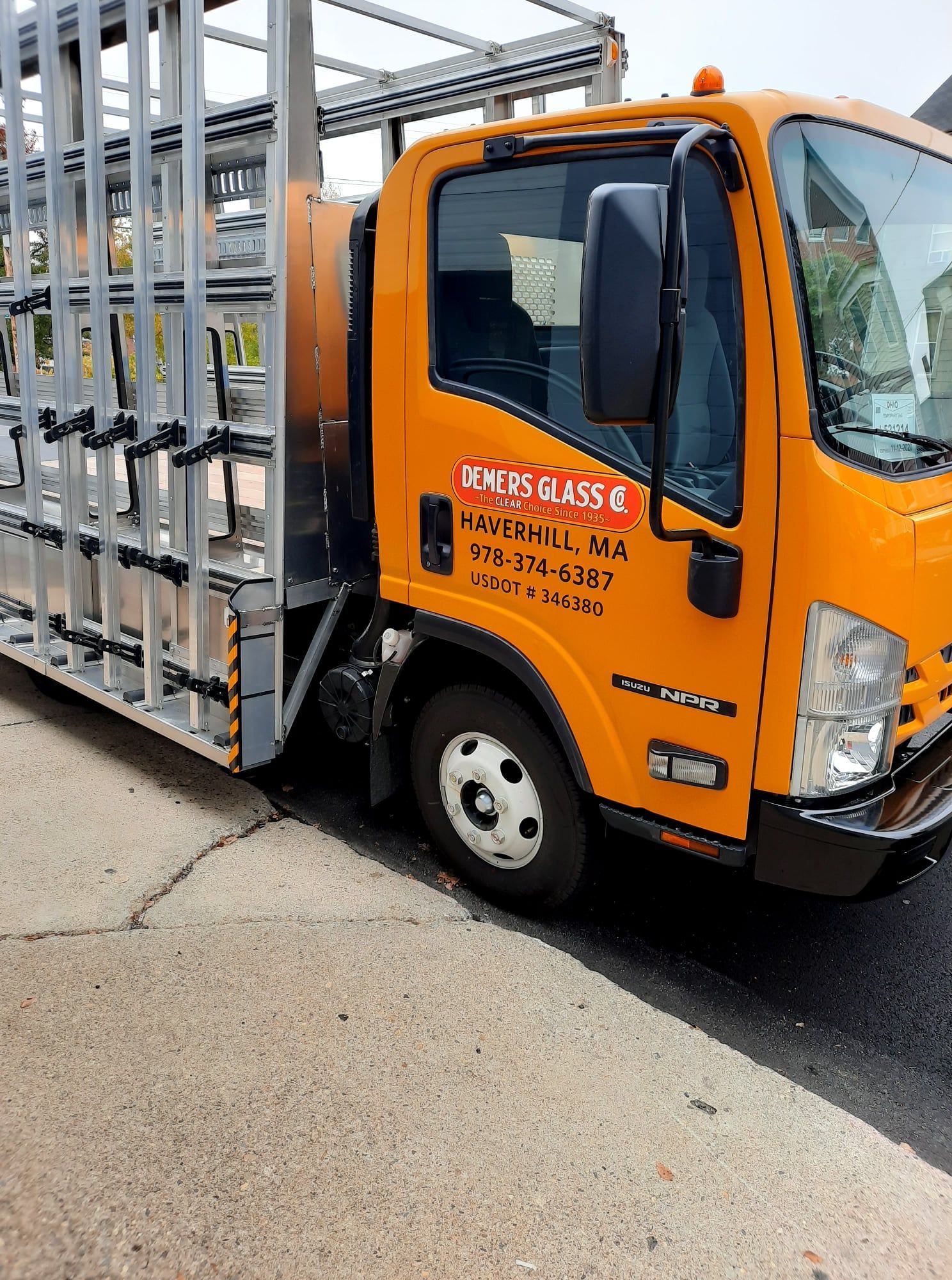 A yellow truck is parked on the side of the road.