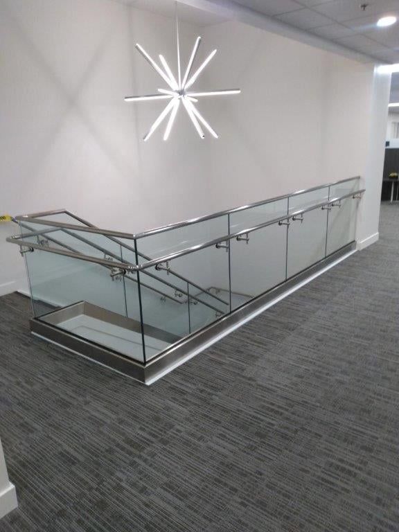 A staircase with a glass railing and a light hanging from the ceiling.
