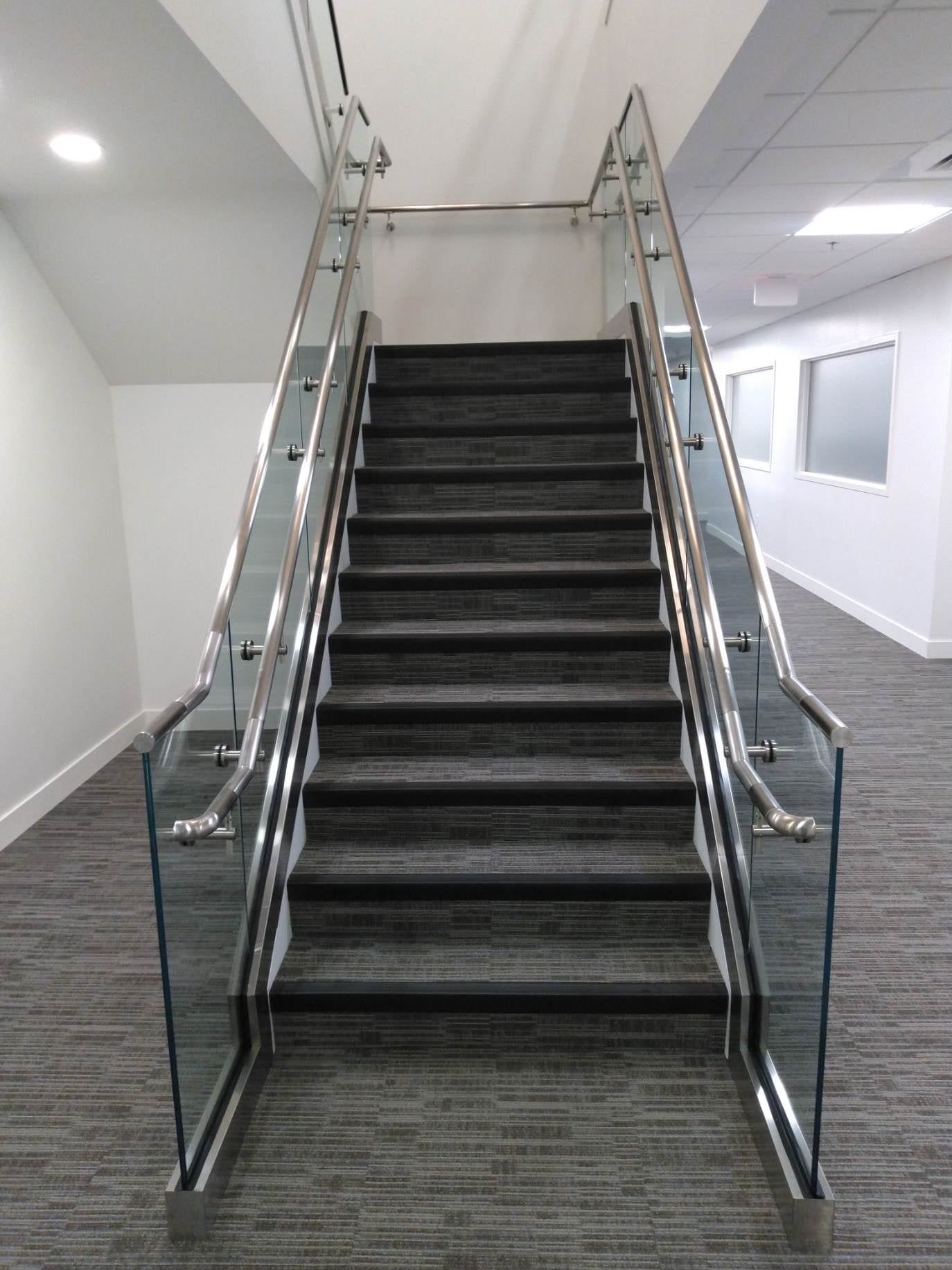 A set of stairs with a glass railing in a building.