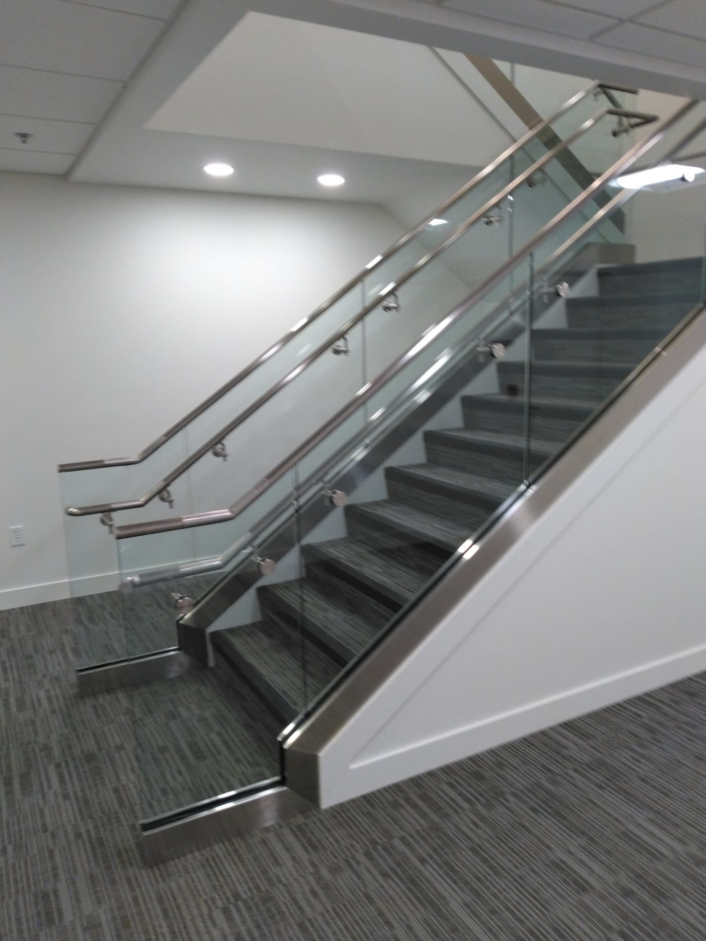 A staircase with a glass railing in a building