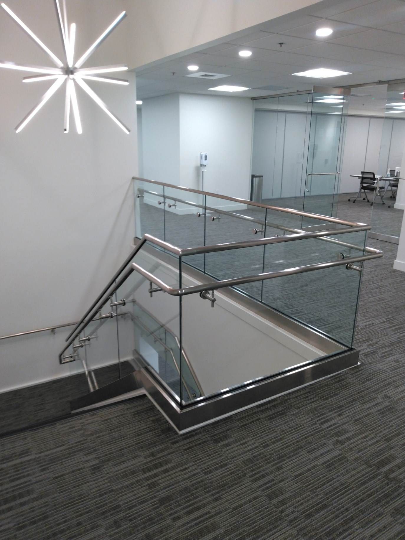 A staircase with a glass railing in an office building.