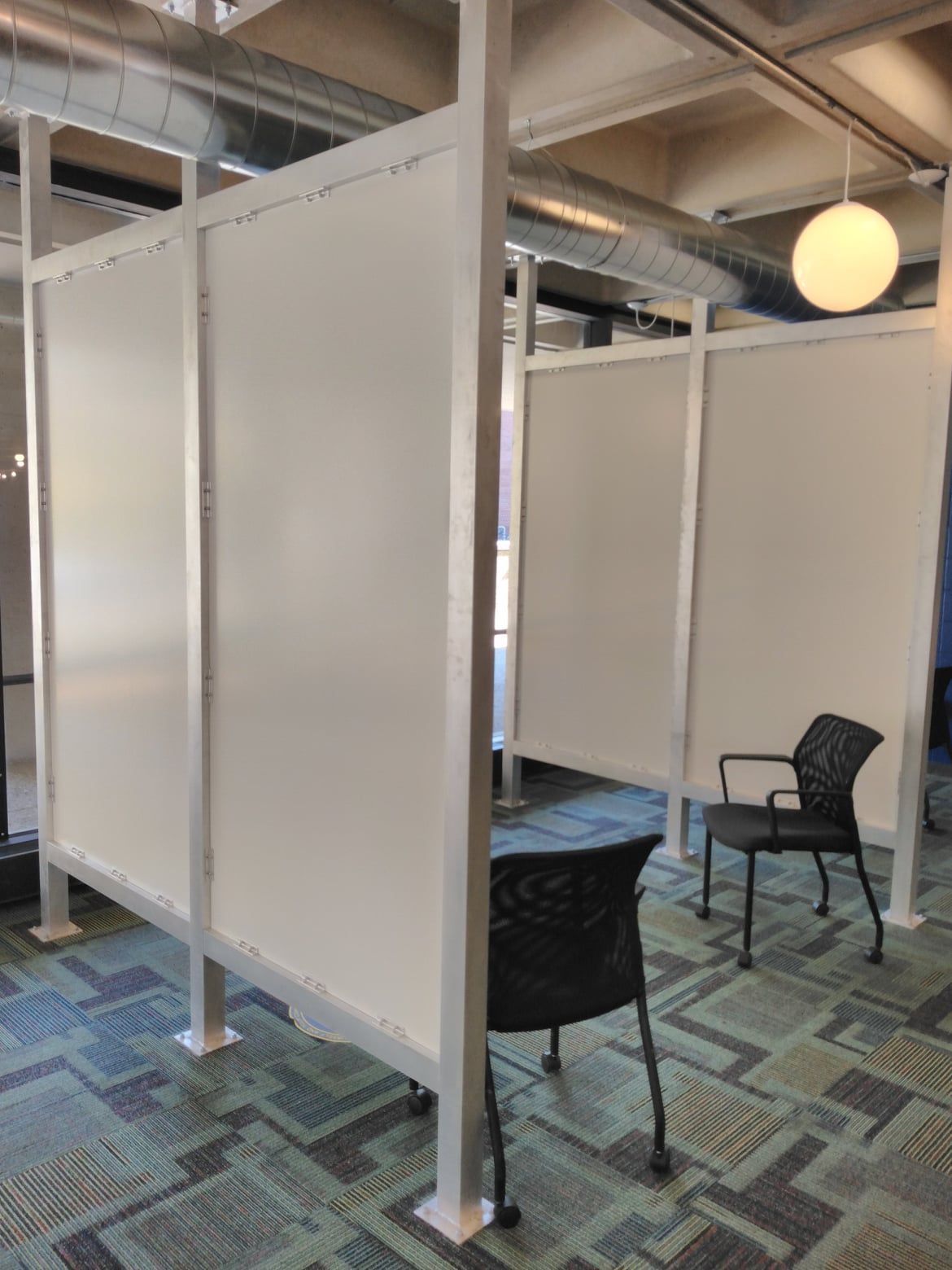 A room with a chair and a table between two white walls.