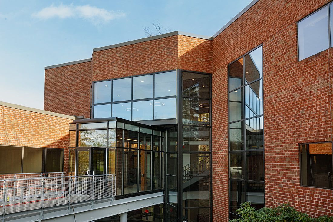 A large brick building with a lot of windows and a balcony.