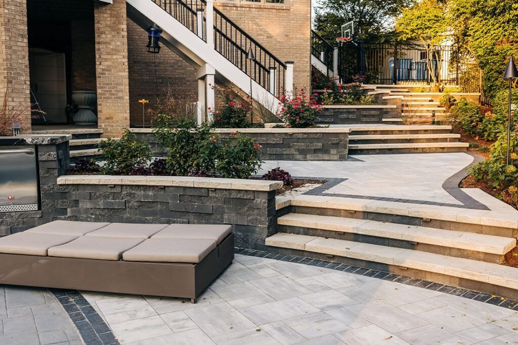 Outdoor patio with steps, a sunbed, and tiered landscaping.