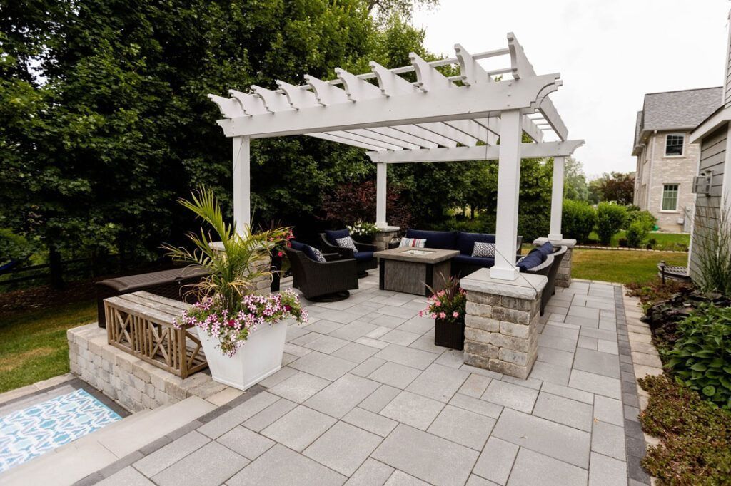 Patio with white pergola, outdoor seating, and a fire pit.