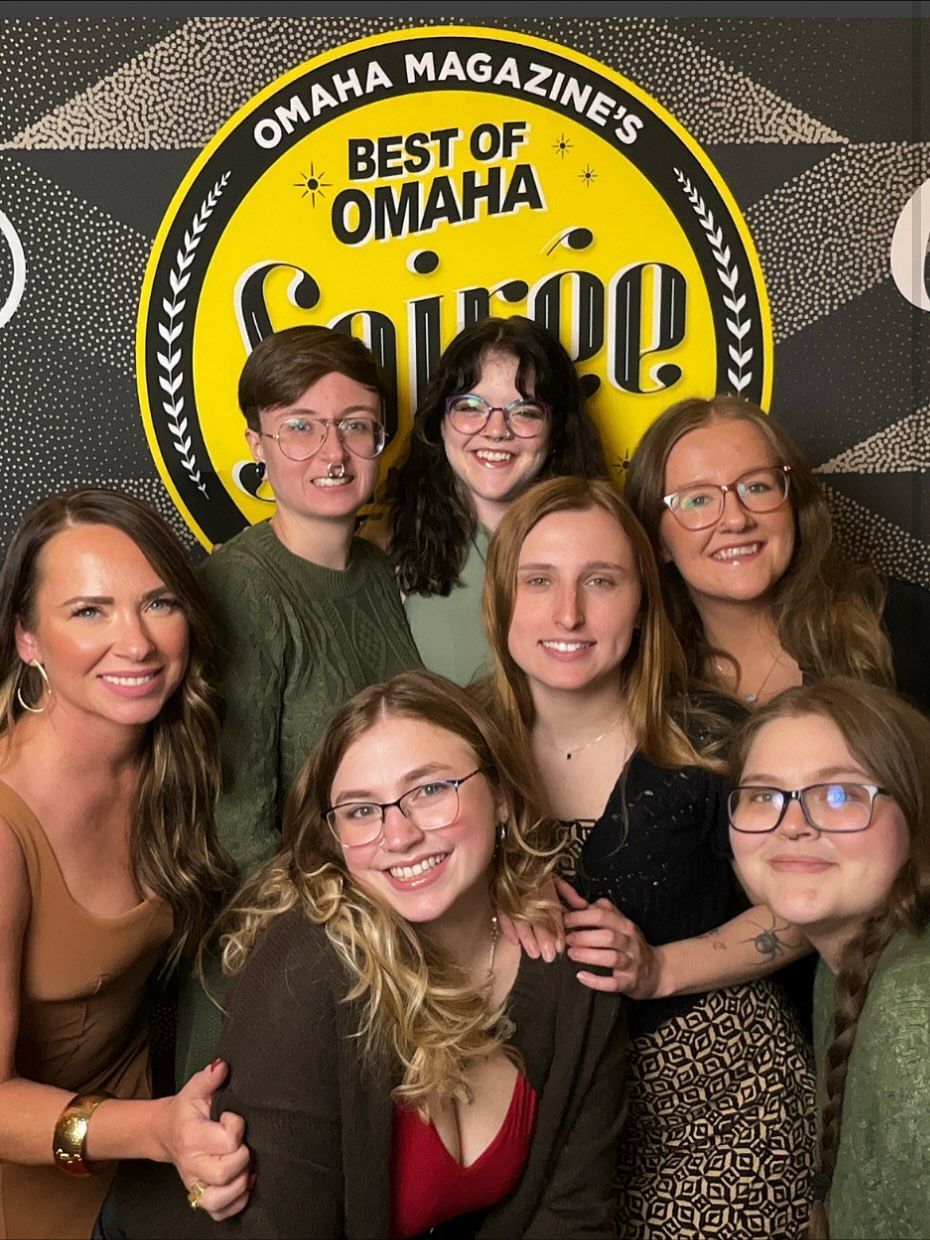 Group of seven smiling people in front of 