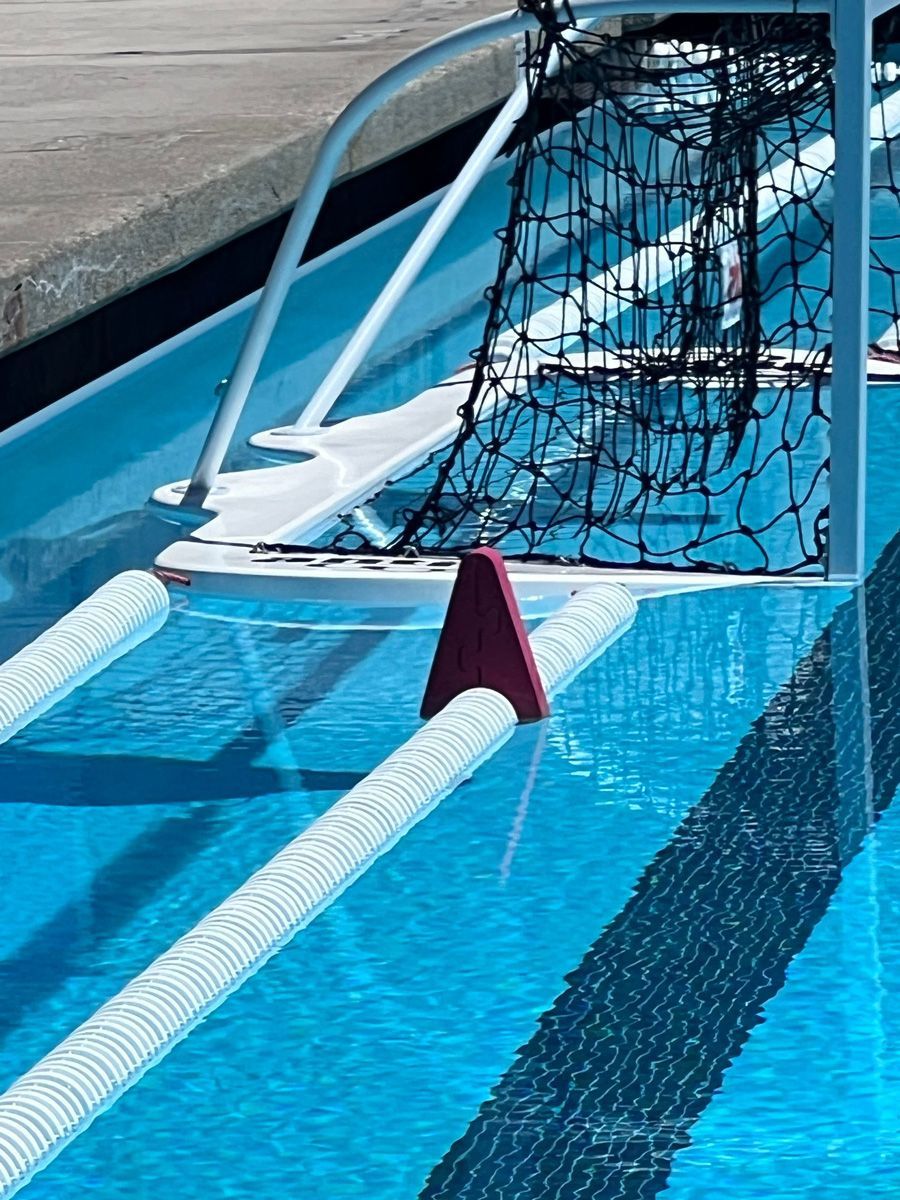 Partially submerged soccer goal in a blue swimming pool, with net draped over the frame