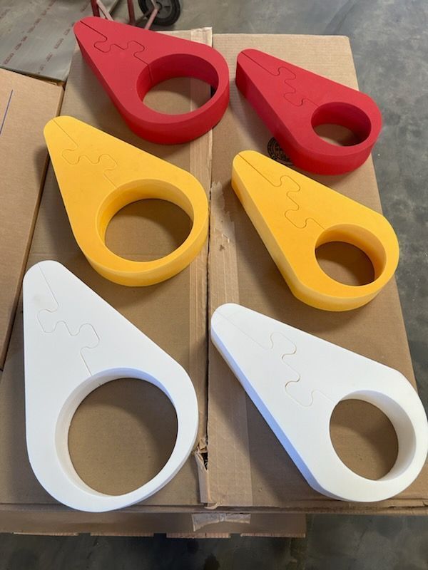 Six colorful plastic ring-shaped objects—red, yellow, and white—arranged on cardboard boxes.