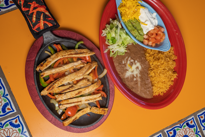 Two plates of mexican food are sitting on a table.