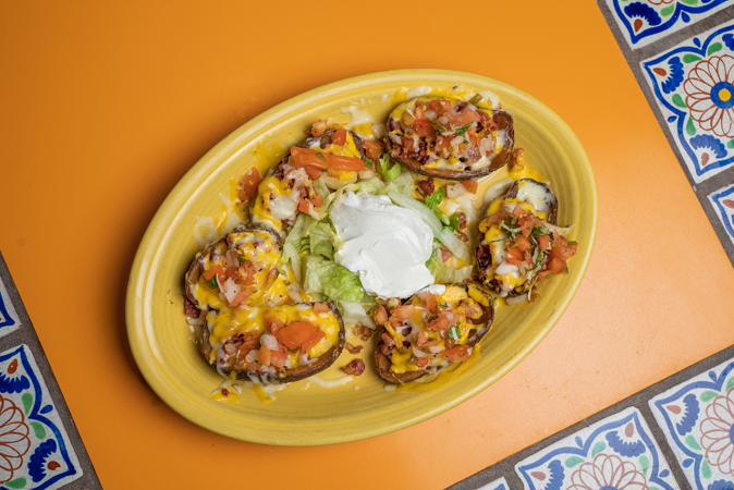 A yellow plate topped with a variety of food on a table.