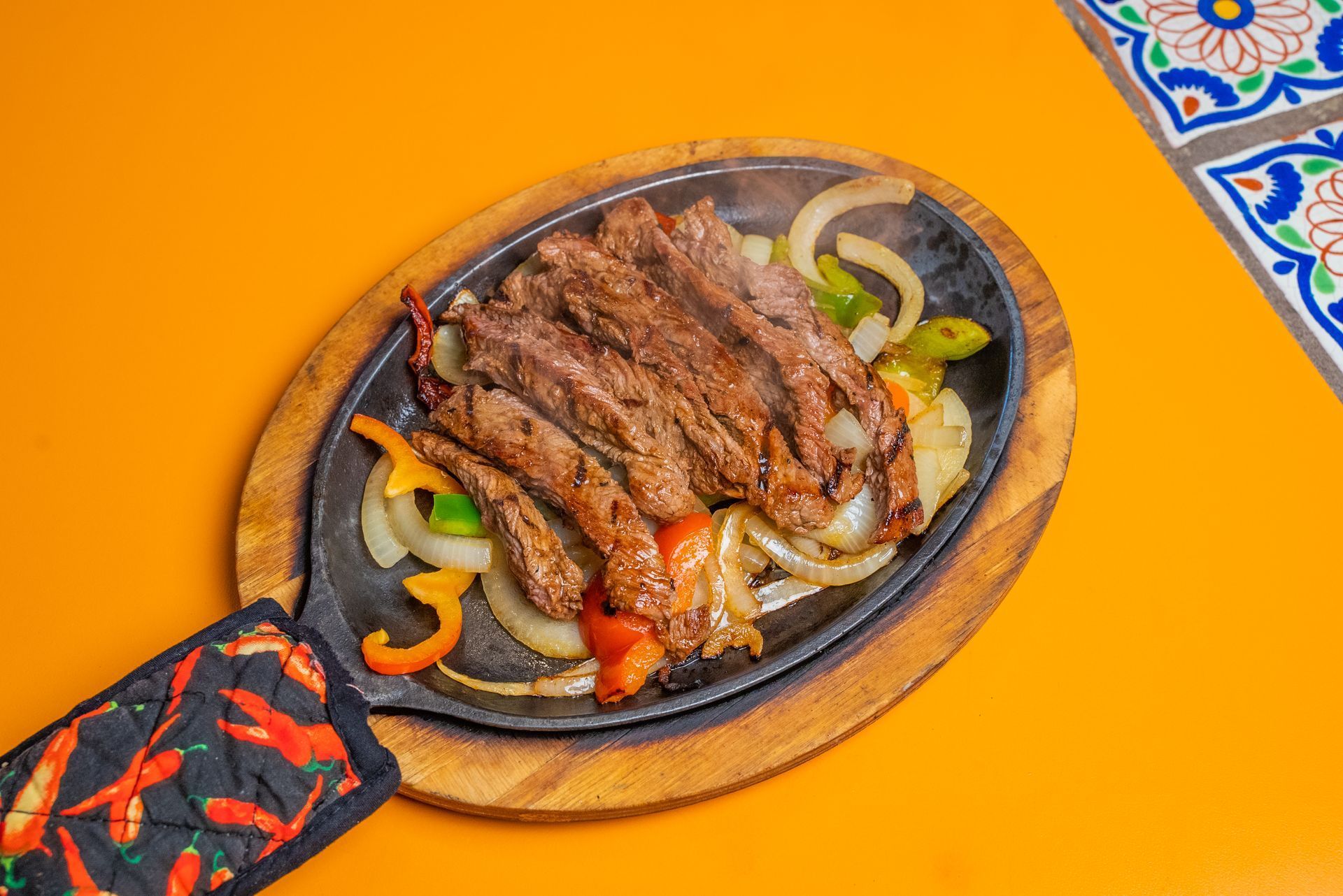 A close up of a plate of food with meat and vegetables on a table.