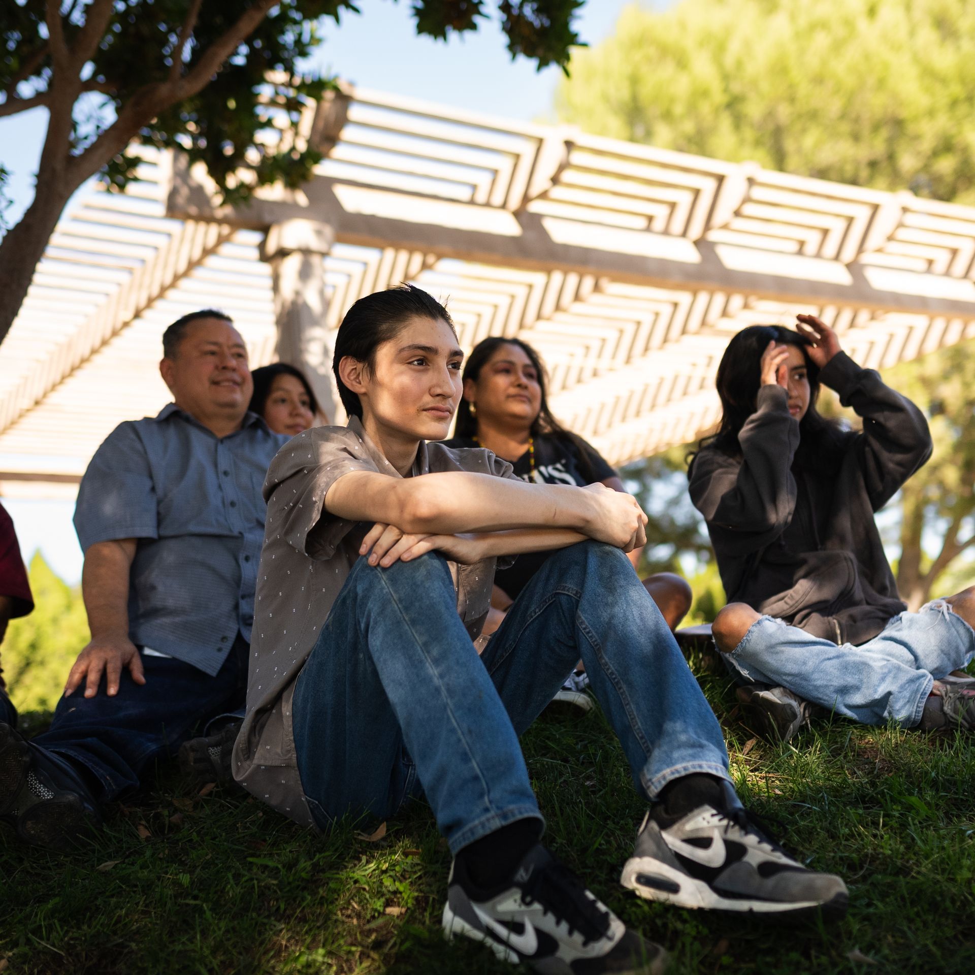 A group of people sitting on the grass 