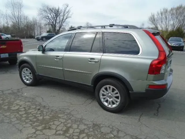 Silver SUV parked in a cracked asphalt lot with leafless trees in the background.