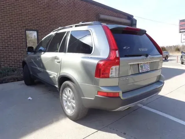 Gray SUV crashed into a brick wall beside a sidewalk, front-left side heavily damaged.
