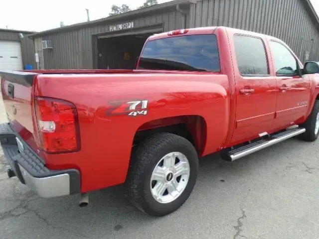 Red pickup truck parked outside a warehouse building