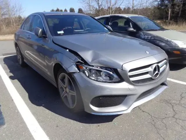 Silver Mercedes sedan with front-end damage parked beside a dark car in a lot