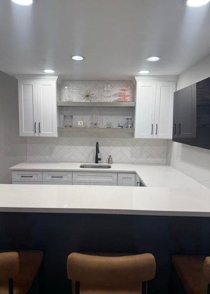 White kitchen bar with light countertops, white cabinets, and dark lower bar.