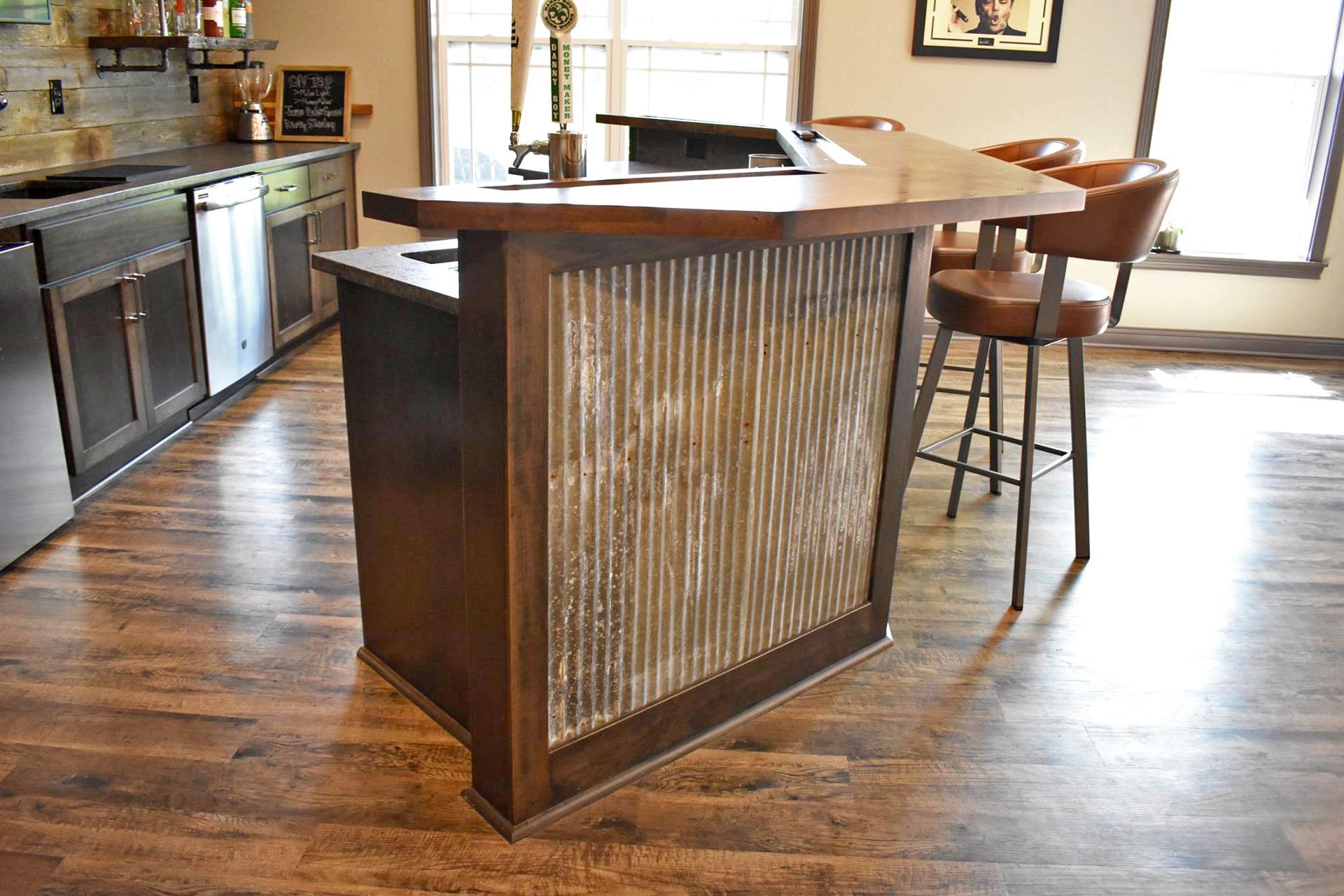 Wooden home bar with corrugated metal panels, stools, and built-in tap.