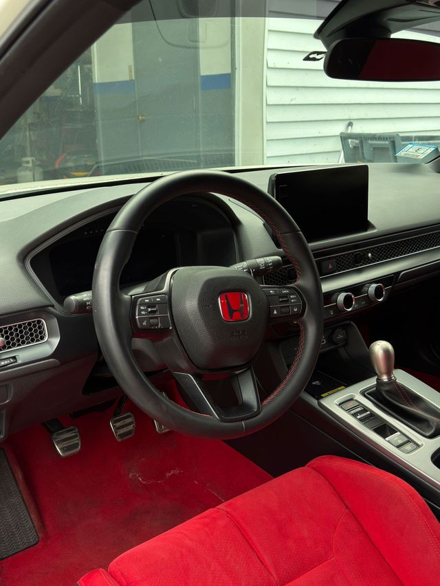 Red Honda car interior with black dashboard, red seats, and center console visible.