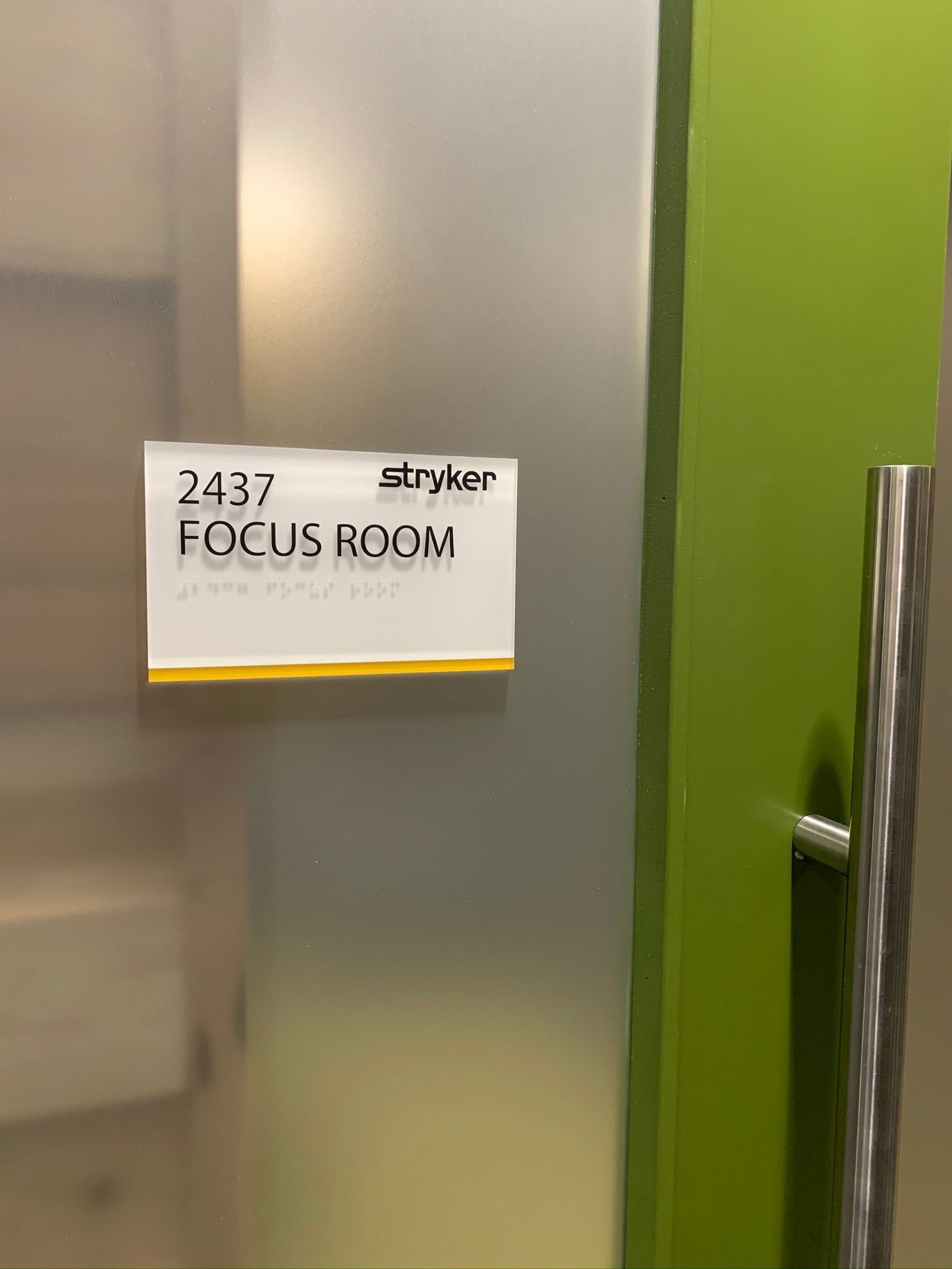 Focus room sign on frosted glass door with green frame and chrome handle.