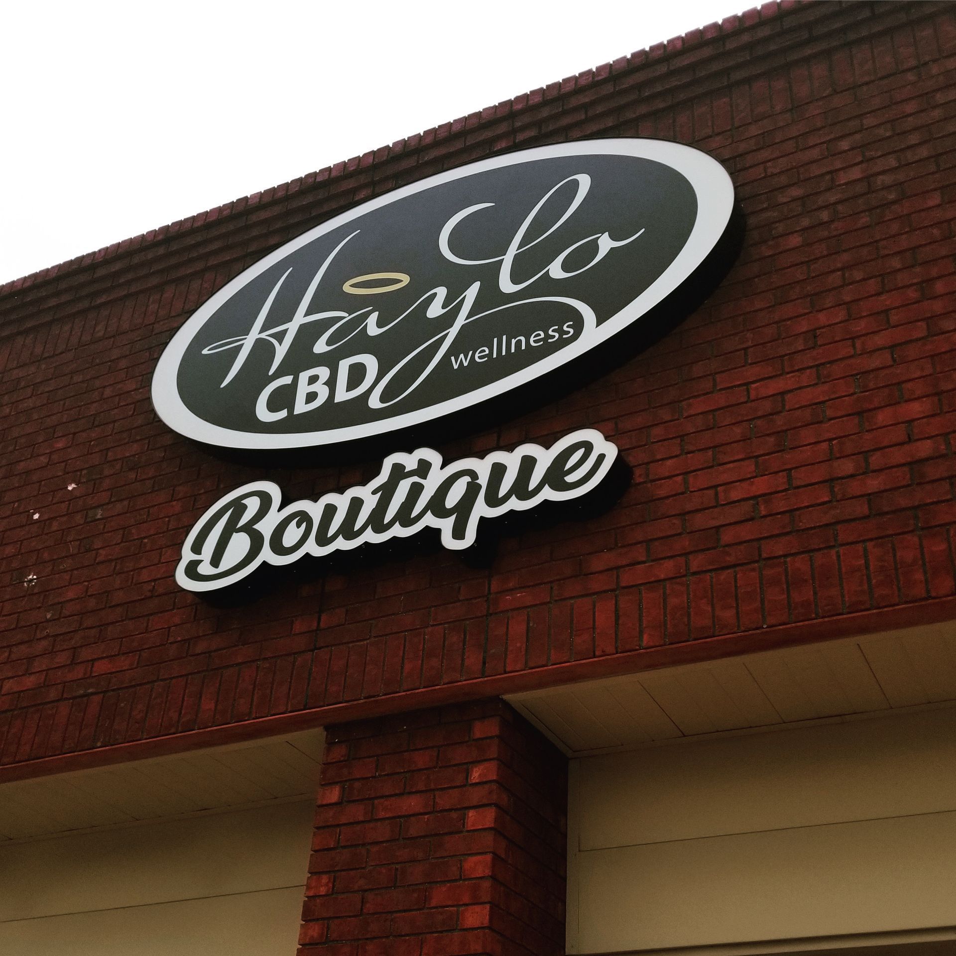 Haylo CBD Wellness Boutique sign on a brick building exterior