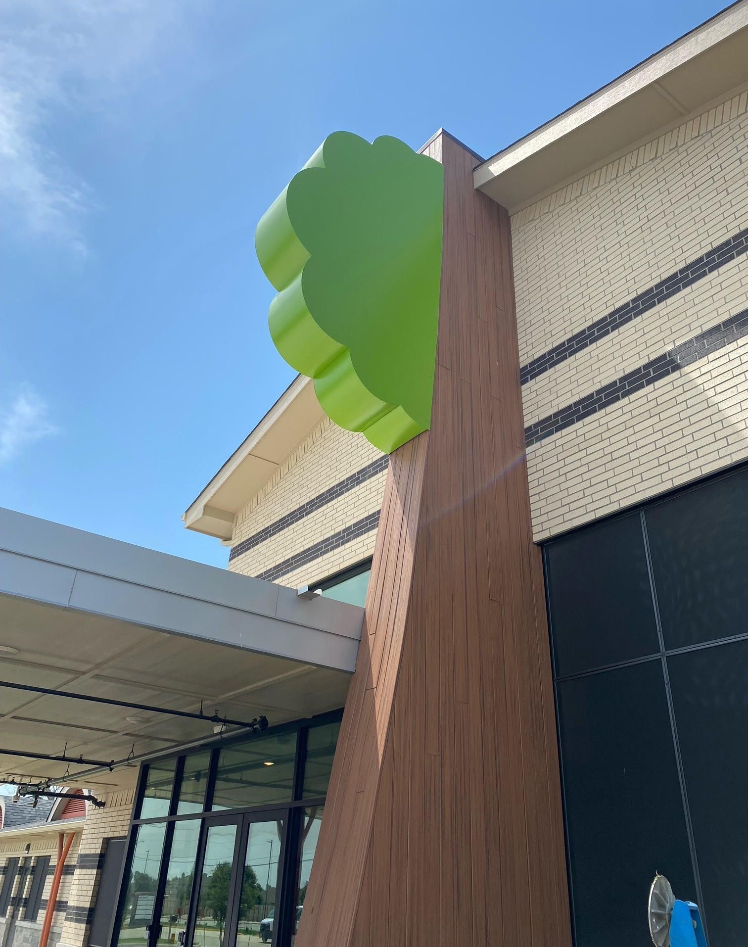 Custom architectural tree element installed on the building for Deep Roots Montessori in Murphy, TX.