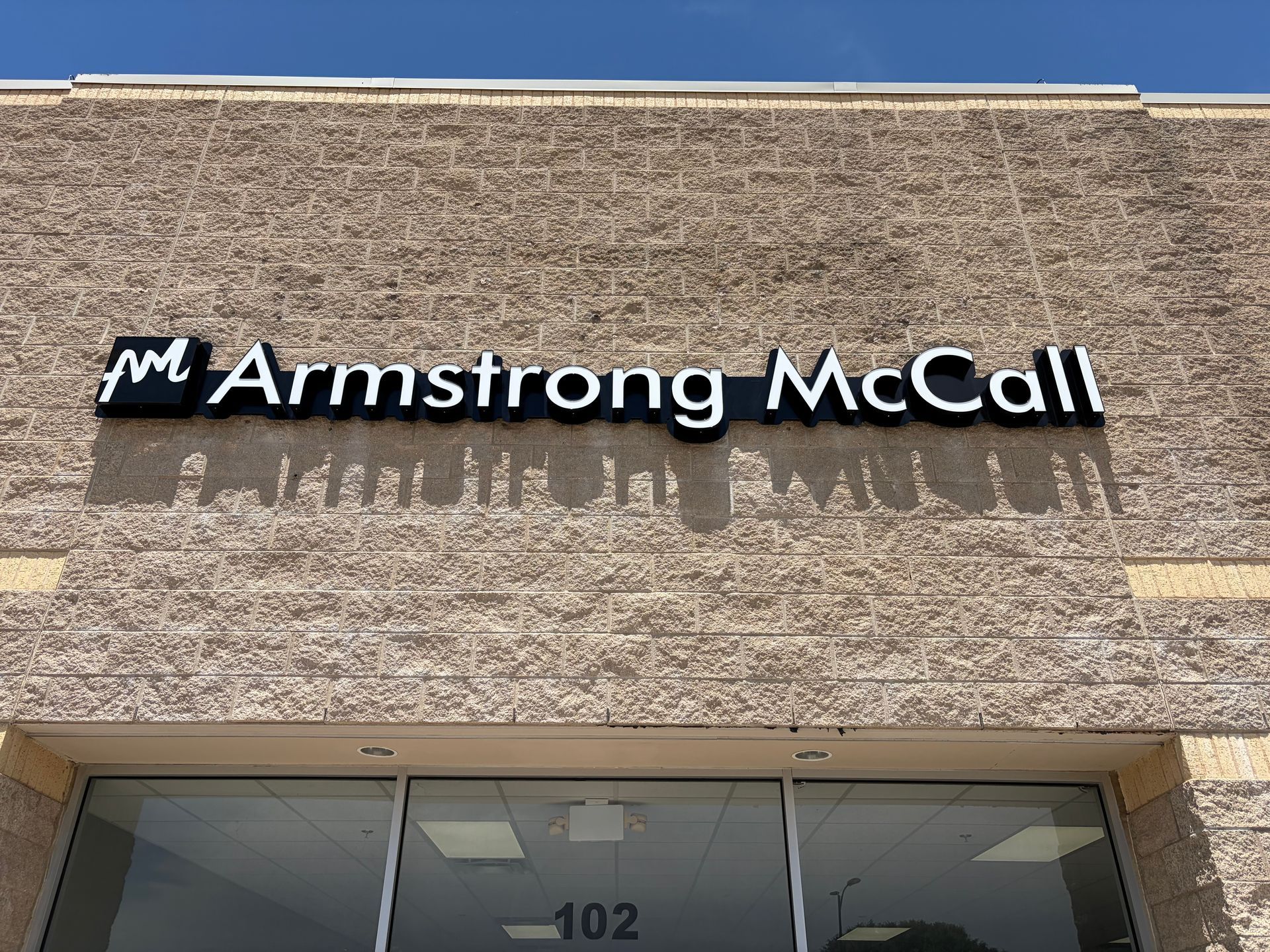 Armstrong McCall storefront sign on a beige building facade