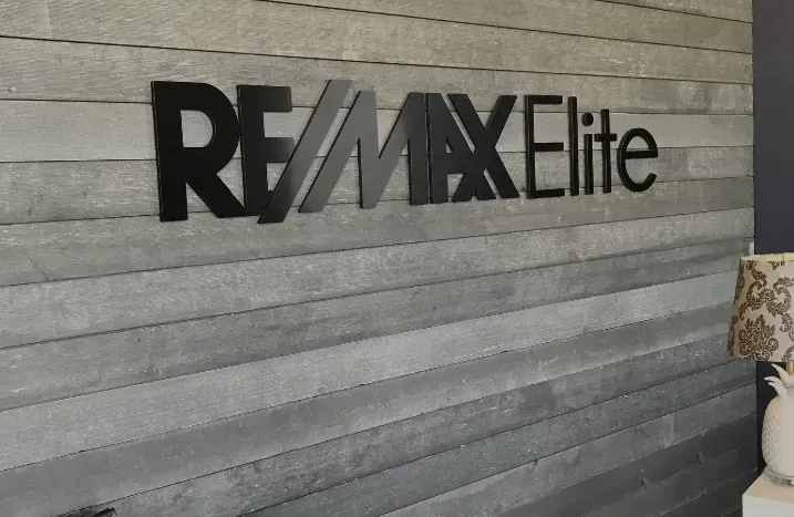 RE/MAX Elite sign on a gray wall interior.