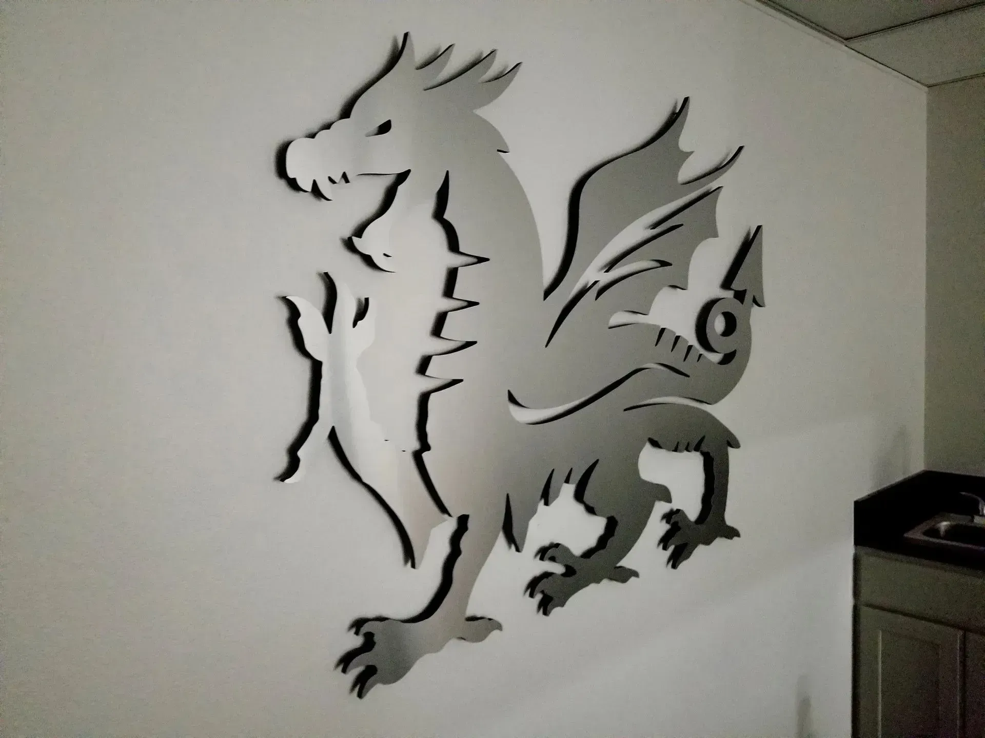 Dragon wall decal on a white wall beside a kitchen cabinet.