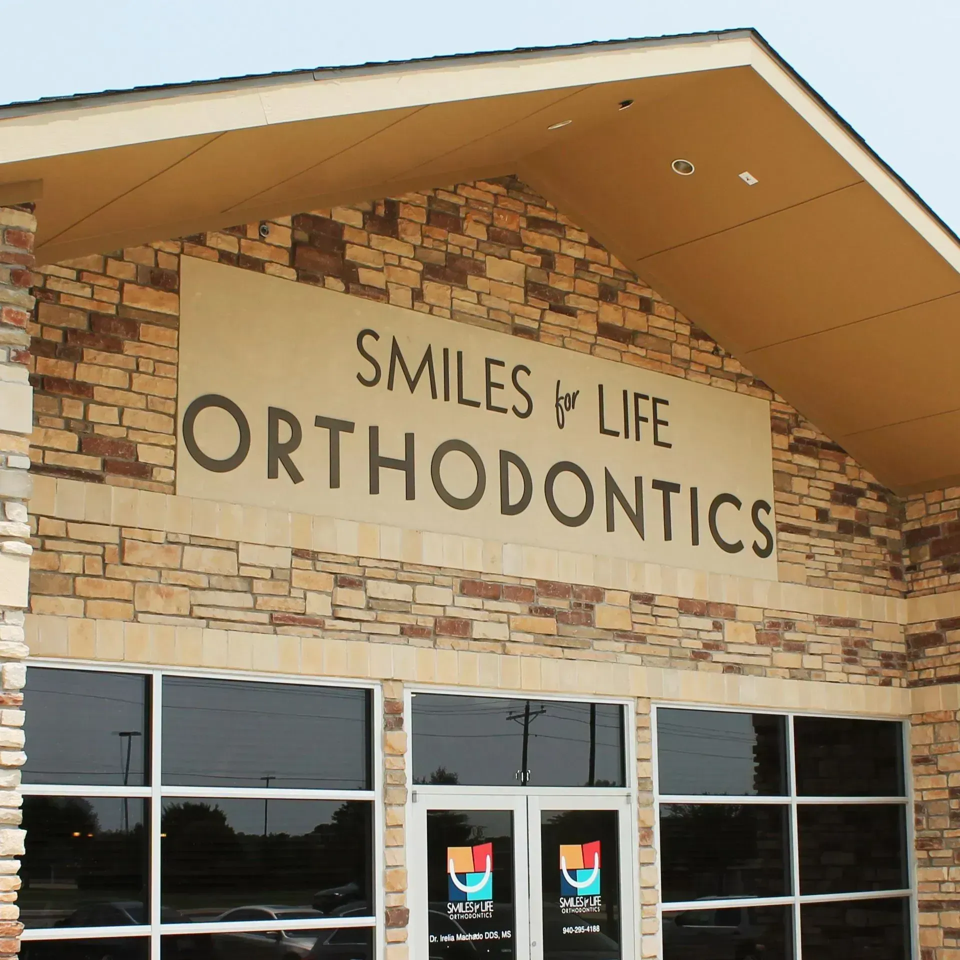 Smiles for Life Orthodontics storefront with stone facade and large windows.