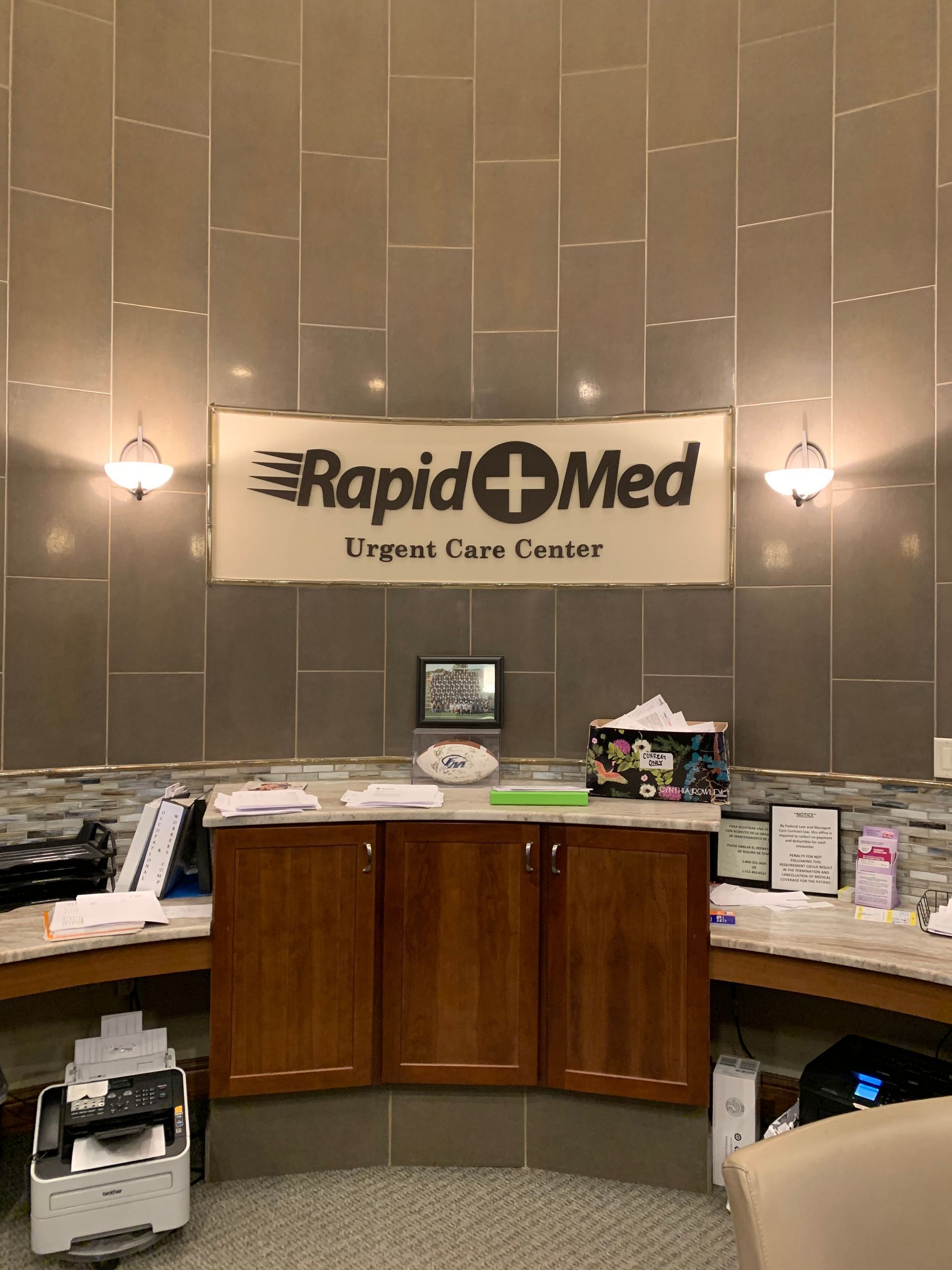 Rapid Med Urgent Care lobby with front desk, sign, and softly lit beige walls