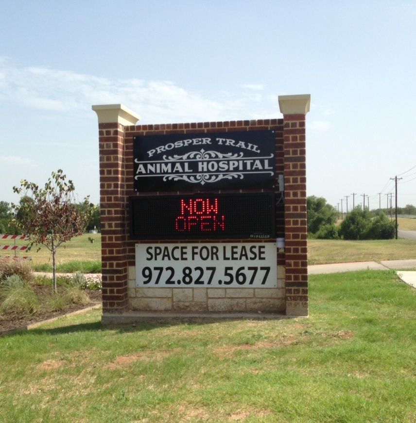 Brick sign for Proper Trail Animal Hospital with neon “Not Open” and “Space for Lease” notice.