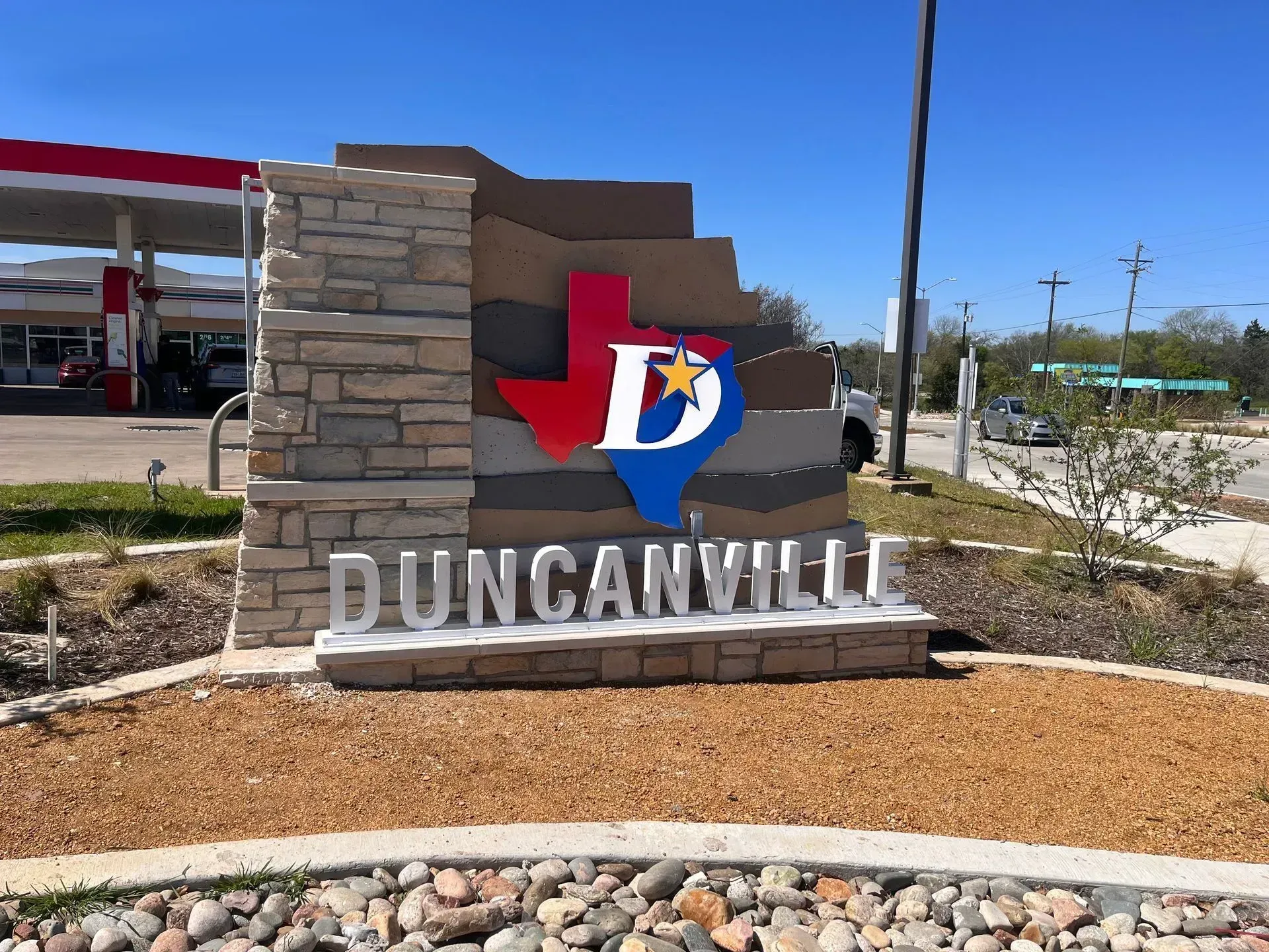 Duncanville city welcome sign with Texas outline and stone base in a landscaped roadside area