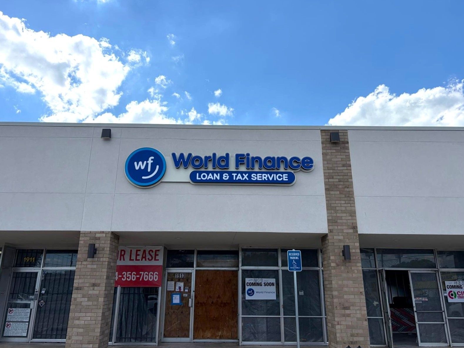 World Finance storefront with “For Lease” signs under a blue sky