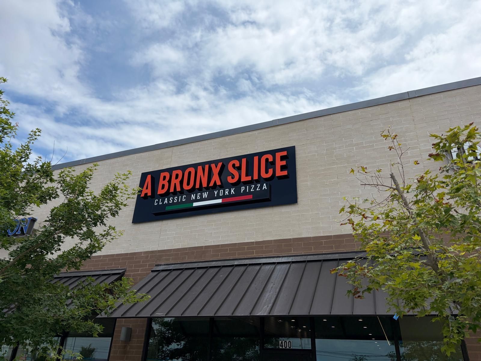 A Bronx Slice restaurant storefront sign with dimensional lettering in Frisco, TX.